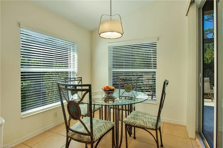 Dining room with light tile patterned flooring, healthy amount of natural light, and lofted ceiling