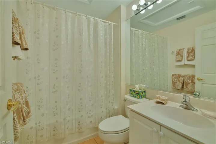 Full bath featuring vanity, shower / bath combo, and light tile patterned floors