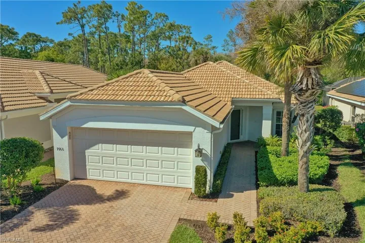 View of front of property with decorative driveway, stucco siding, an attached garage, and a tiled roof