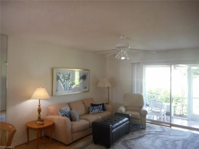 Living area featuring ceiling fan and a textured ceiling