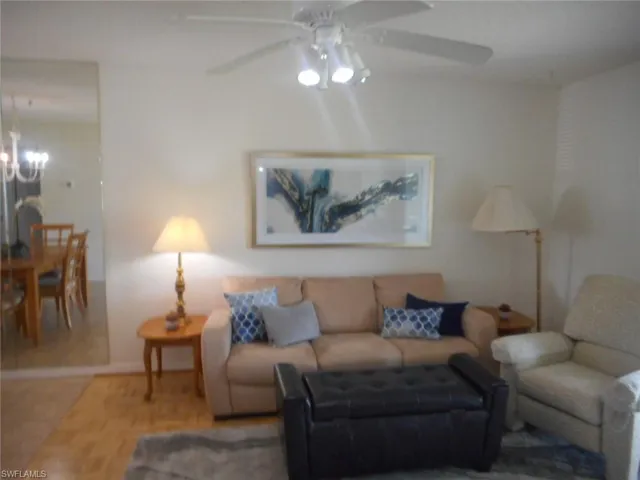 Tiled living room with ceiling fan and a chandelier