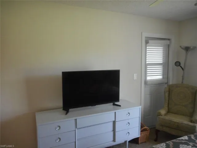 Bedroom featuring dark carpet, a textured ceiling, and ceiling fan