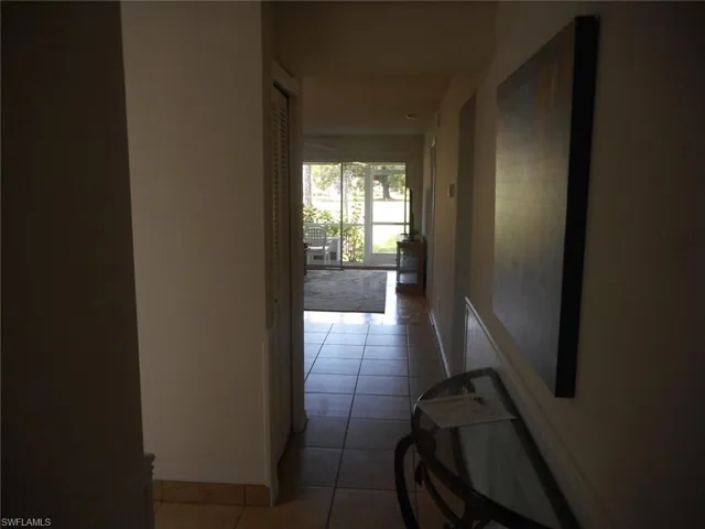 Corridor featuring light tile patterned floors and baseboards