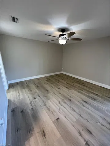 Empty room featuring light wood-type flooring and ceiling fan