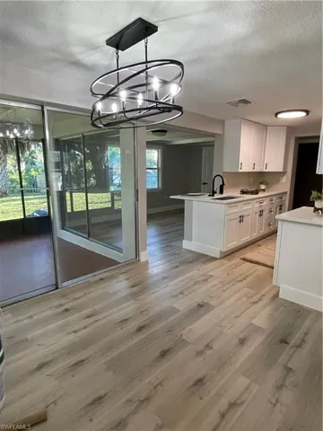 Unfurnished dining area with light hardwood / wood-style flooring, a textured ceiling, and sink