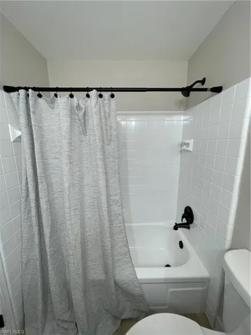Bathroom featuring shower / tub combo and toilet