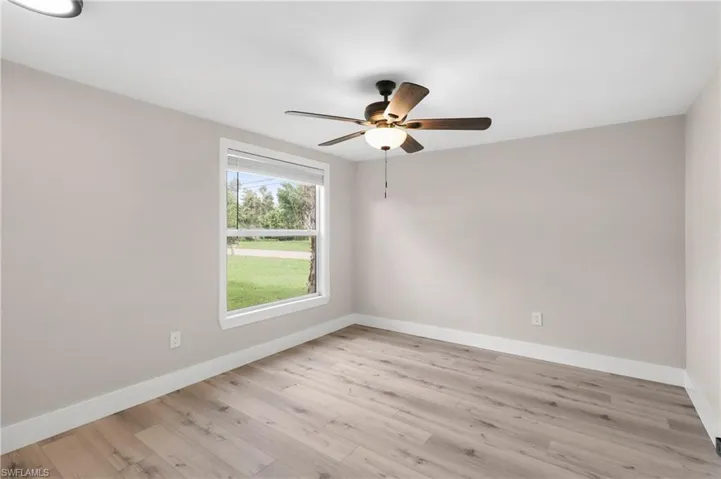 Unfurnished room with light wood-type flooring and ceiling fan