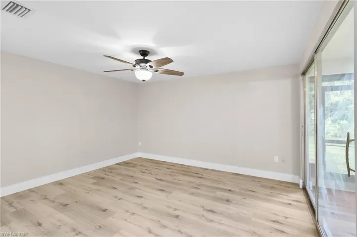 Empty room with ceiling fan and light hardwood / wood-style flooring