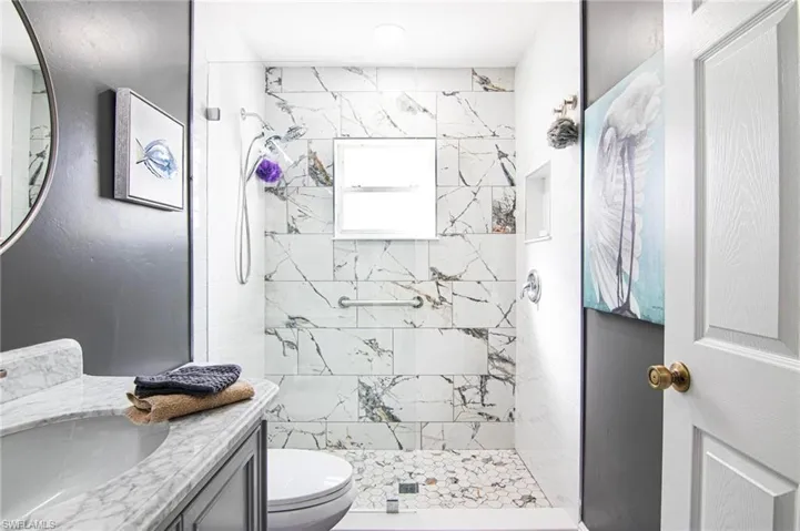 Bathroom with a marble finish shower and vanity