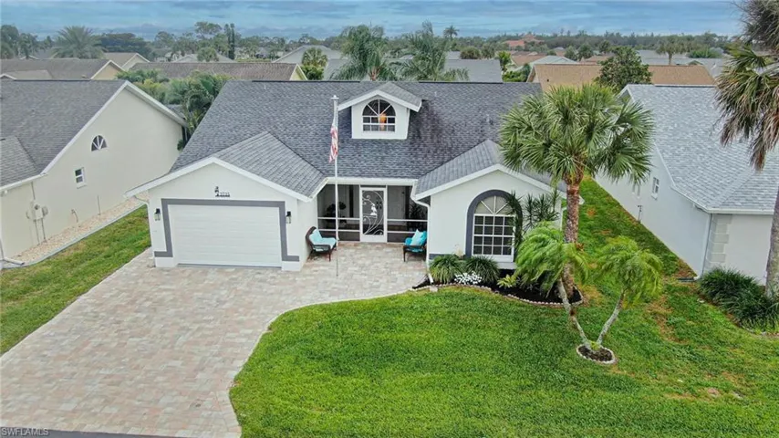 View of front of property with roof with shingles, an attached garage, decorative driveway, and a front yard