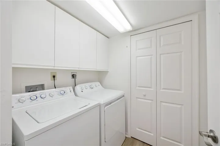 Laundry room with washer and dryer, closet, and cabinet space