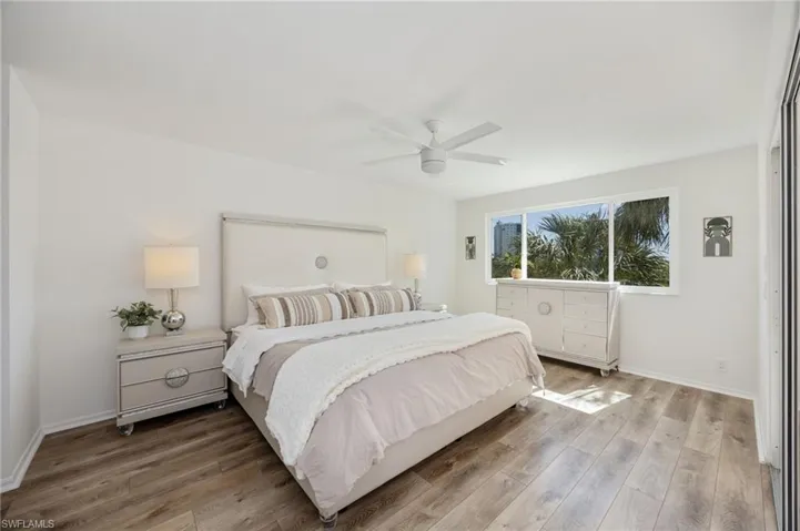 Primary Bedroom enjoys views to the lanai, lake & Wiggins Bay