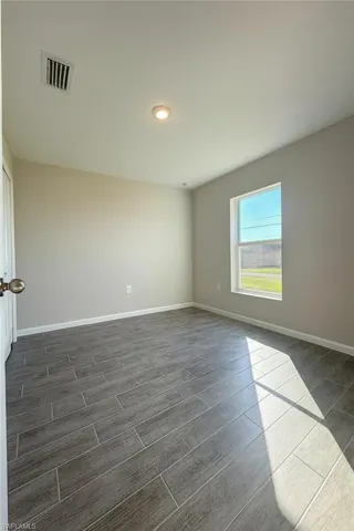 Spare room with wood finish floors and recessed lighting