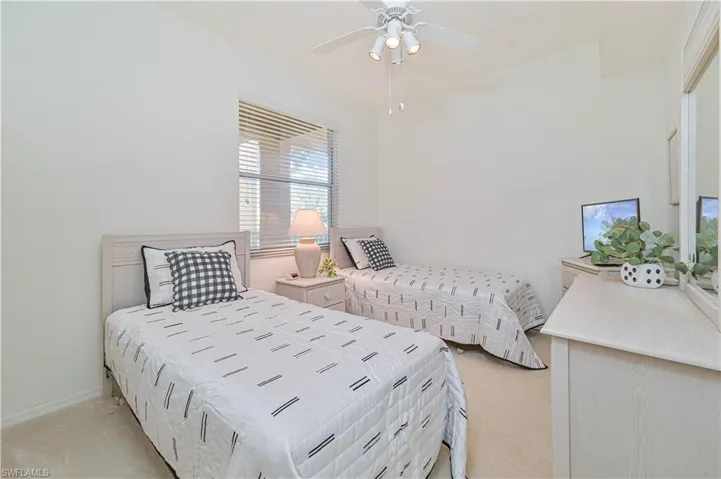 Bedroom with light carpet and a ceiling fan