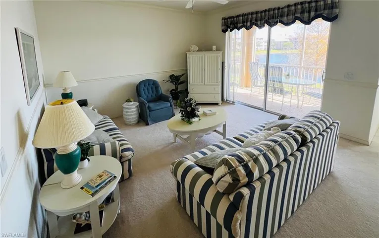 Carpeted living room featuring a ceiling fan