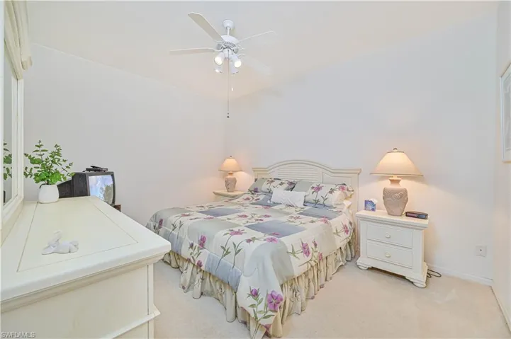 Bedroom with light colored carpet and a ceiling fan