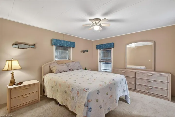 Carpeted bedroom featuring a ceiling fan