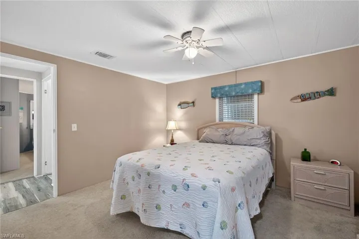 Bedroom featuring ceiling fan, carpet, and a textured ceiling