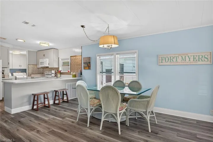 Dining room featuring washer / clothes dryer, dark wood-style floors, and ornamental molding
