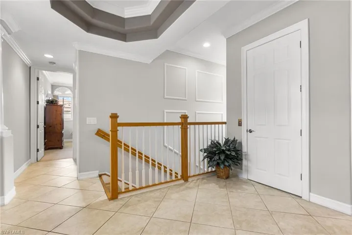 This is the landing at the top of the staircase. Double Tray ceiling. Light decorative wainscoting on the stairwell wall.