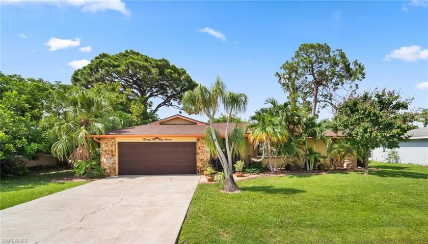 Ranch-style home with a garage and a front lawn