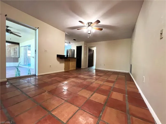 Spare room with tile patterned flooring, ceiling fan, and baseboards