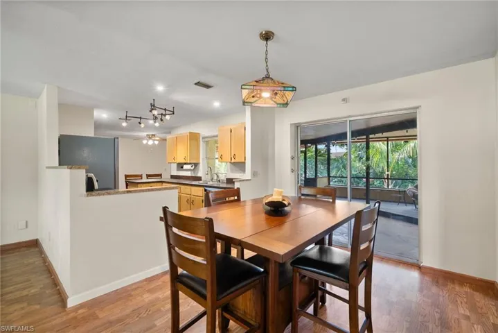 Dining area with rail lighting and hardwood / wood-style flooring