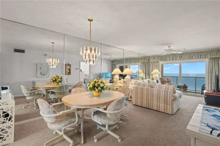 Dining room with carpet floors, a ceiling fan, and a chandelier