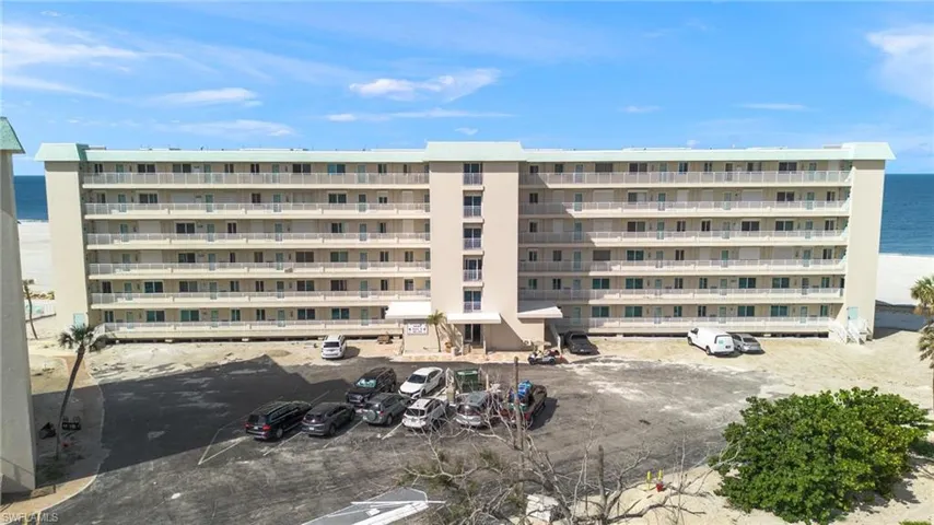 View of apartment building / complex with a water view and uncovered parking