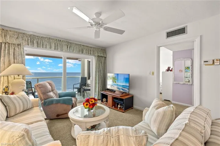 Living room with carpet flooring and ceiling fan