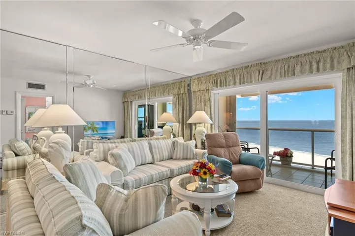 Carpeted living area featuring ceiling fan
