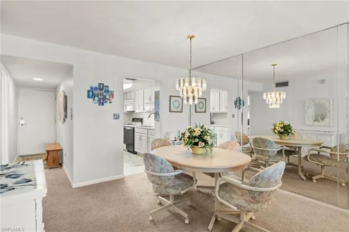 Dining space featuring a chandelier and light colored carpet