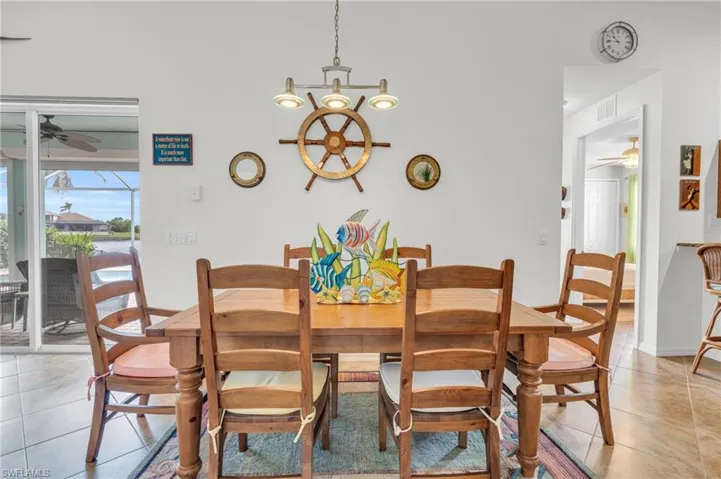 Dining area featuring light tile patterned flooring, visible vents, and ceiling fan