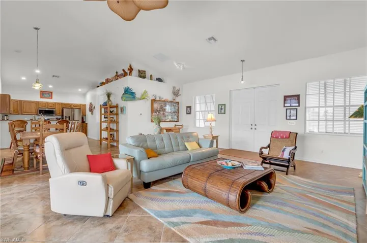 Living room with light tile patterned floors, a healthy amount of sunlight, ceiling fan, and visible vents