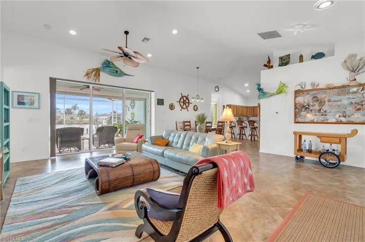 Living area with recessed lighting, lofted ceiling, ceiling fan, and visible vents