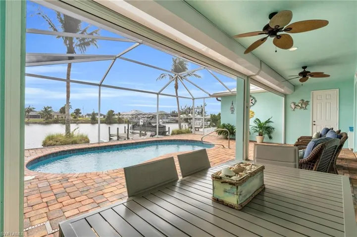 Outdoor pool featuring a lanai, a patio, boat lift, a dock, and a water view