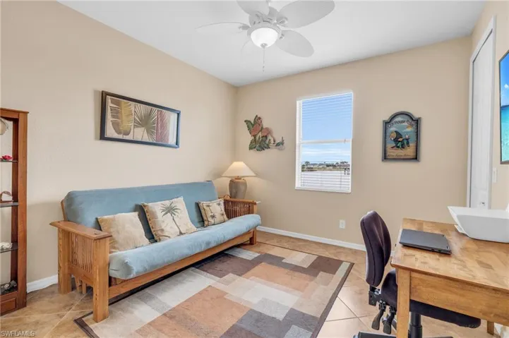 Office featuring a ceiling fan, light tile patterned flooring, and baseboards