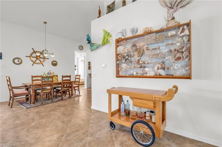 Tiled dining space featuring baseboards, a high ceiling, and a chandelier