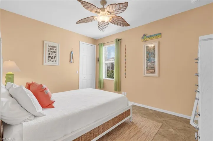 Bedroom featuring light tile patterned flooring, baseboards, a closet, and a ceiling fan