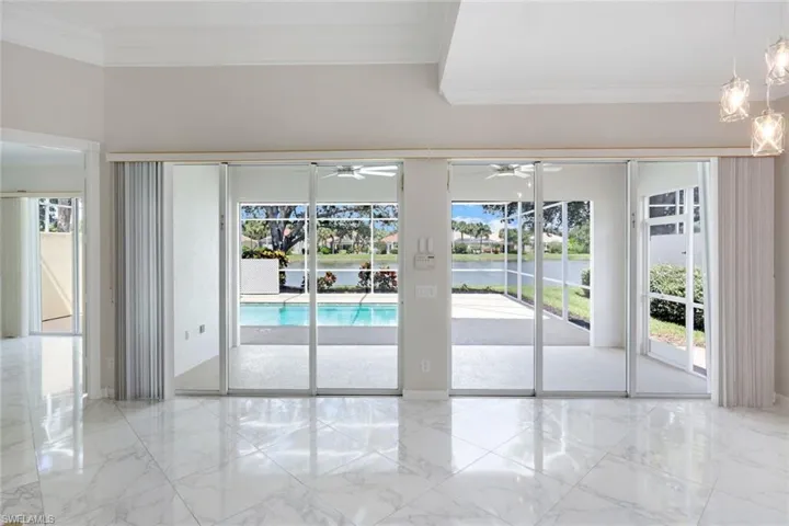 Entryway featuring a water view, crown molding, and marble tiled flooring