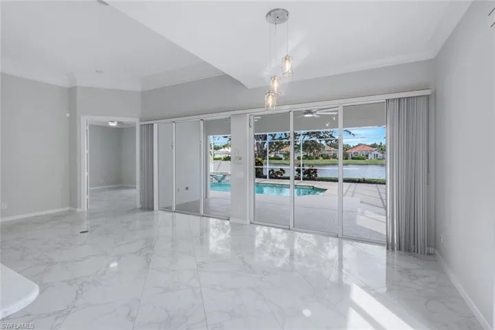 Unfurnished room with light marble finish flooring, crown molding, and a water view