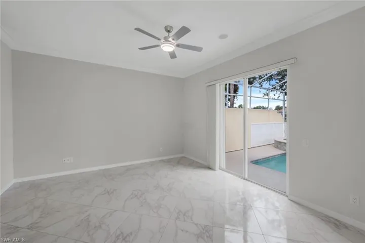 Spare room with light marble finish flooring, crown molding, and ceiling fan