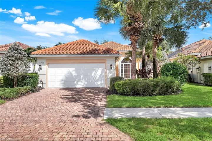 Mediterranean / spanish home with decorative driveway, stucco siding, a tile roof, an attached garage, and a front lawn