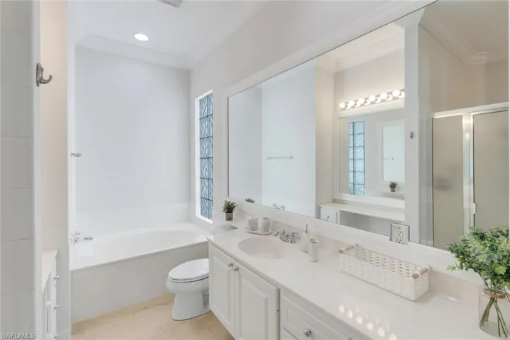 Full bathroom featuring ornamental molding, a bath, vanity, a stall shower, and recessed lighting