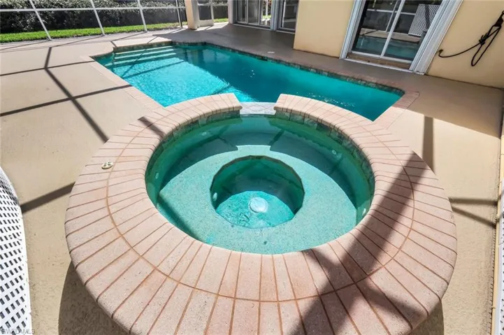 View of swimming pool featuring a patio area and a pool with connected hot tub