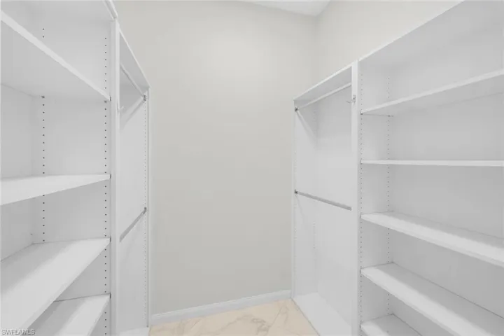 Walk in closet with light marble finish floors