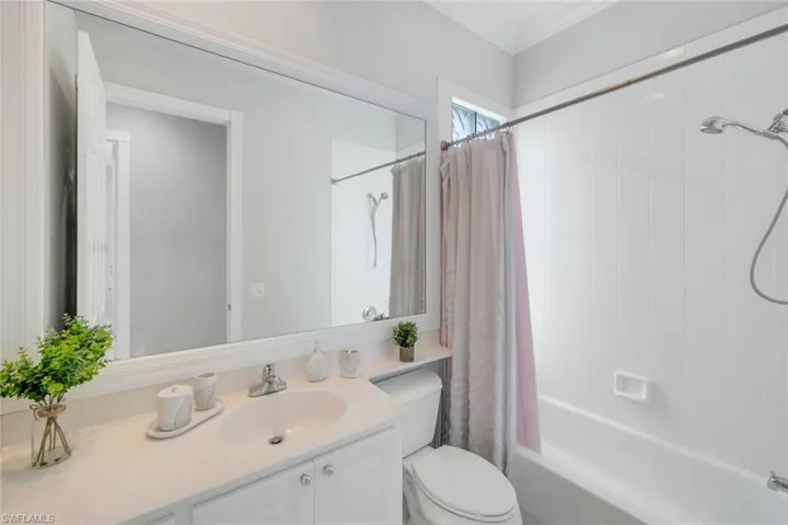 Bathroom with shower / bath combination with curtain, vanity, and ornamental molding