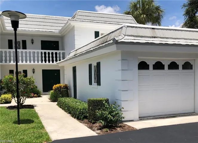 View of front of home featuring a balcony and a garage