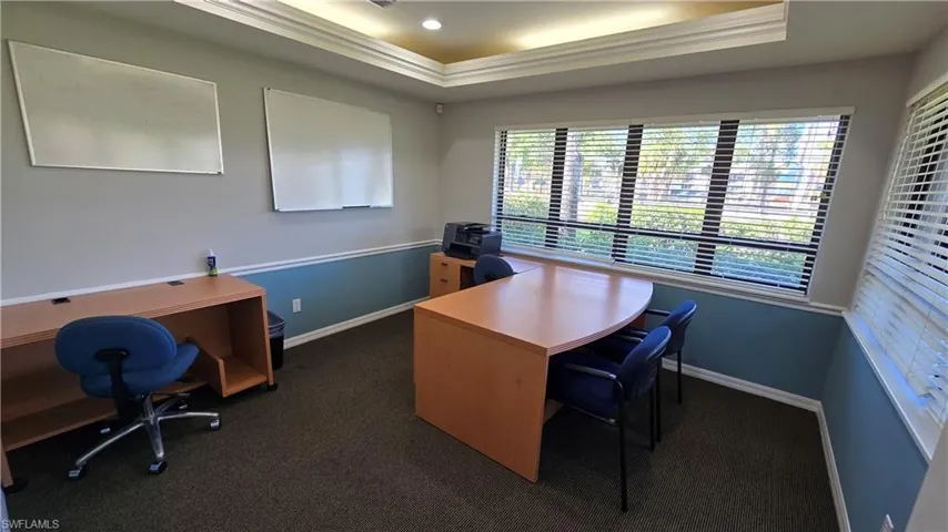 Home office with a raised ceiling and crown molding