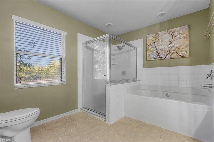 Full bath featuring a soaking bath and shower
